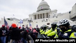 Поддржувачите на Трамп се обидуваат да ја пробијат полициската бариера во Кпитол во Вашингтон. 6 јануари 2021 година.