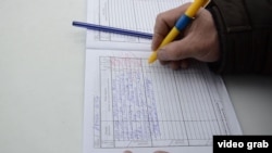 Местный житель расписывается в дневнике оценки деятельности акима района. Казалинск, 9 февраля 2015 года. 