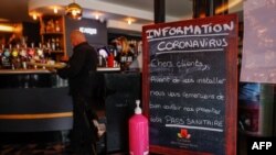 Табела пред входа на кафене в Довил, Франция, която призовава клиентите да покажат на персонала своя здравен пропуск преди да се настанят