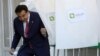 Президент Михаил Саакашвили покидает кабину для голосования на избирательном участке в Тбилиси 1 октября 2012 года. Его партия «Нацдвижение» участвовала в выборах под №5 с 2004 года 