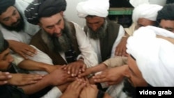 Kép egy 2016-os videófelvételből, amelyen állítólag tálib parancsnokok egy csoportja látható, amint hűséget fogad az akkor kinevezett afgán tálib vezetőnek, Hajbatullah Ahundzáda mollának
