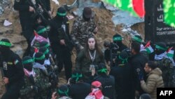 Членове на Хамас ескортират израелската заложничка Агам Бергер, преди да я предадат на екип на Червения кръст, 30 януари 2025 г.