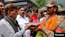 Ljudi u selu Chakothi daju slatkiše vojnicima pakistanske vojske kao dio proslave, nakon prekida vatre između Indije i Pakistana, 11. maja 2025.