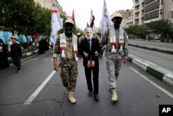 Anëtarët e forcës paramilitare iraniane, Basij, të veshur në stilin e militantëve palestinezë dhe libanezë, interpretojnë arrestimin e kryeministrit të Izraelit, Benjamin Netanyahu, gjatë një tubimi pro-palestinez në Teheran, 13 tetor 2023.