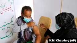 په لاهور کې یو کس د کووېډ-۱۹ واکسیني ستنه لګوي - د ۲۰۲۱ز کال د جولای شپږمې انځور.