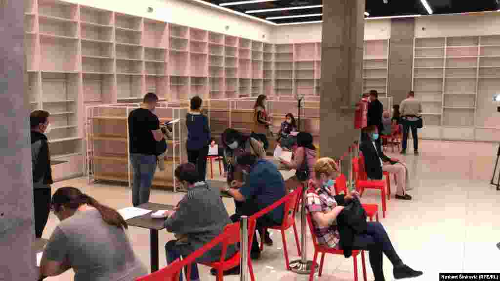 Na levoj strani građani čekaju u redu za vakcinaciju i popunjavaju evidencione formulare, dok na desnoj pauzu prave oni koji su upravo vakcinisani u prvoj stanici otvorenoj u šoping molu u Novom Sadu.&nbsp;