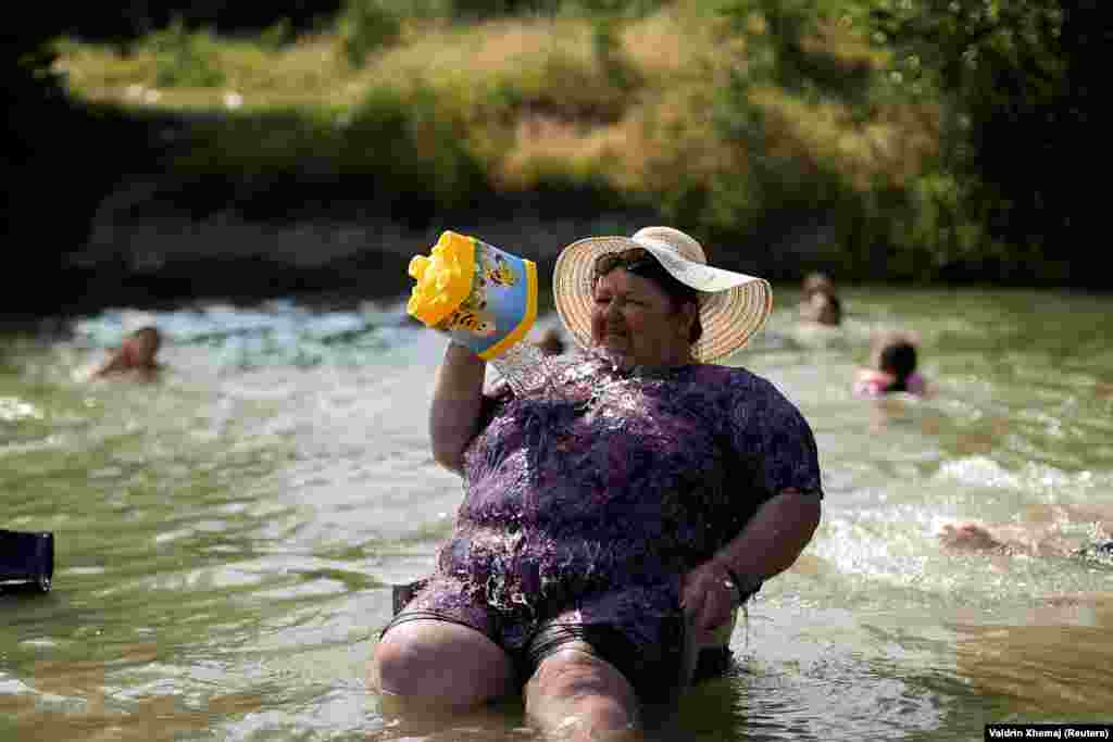 Žena se rashlađuje u rijeci Erenik 25. juna 2025. godine.