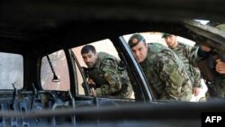FILE: Afghan army soldiers inspect a vehicle which was used in a suicide attack in Farah province.