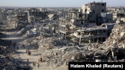 Palestinci prolaze pored ruševina kuća i zgrada uništenih tokom rata, u Rafi u južnom Pojasu Gaze, 20. januara. 