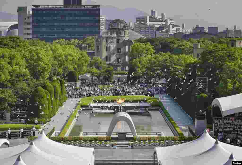 Porumbeii zboară peste Parcul Memorial al Păcii, cu vedere spre Cupola Bombei Atomice distruse, în timpul ceremoniei, la Hiroshima.