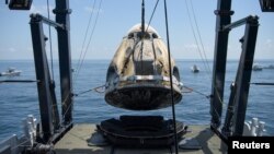 Изваждането на капсулата Dragon от водите на Мексиканския залив. На нея американските астронавти Боб Бенкен и Дъг Хърли успешно достигнаха до Международната космическа станция и се върнаха в неделя обратно на Земята