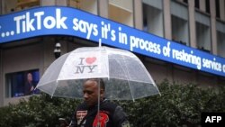 Čovjek u New Yorku prolazi pored natpisa na kojem je objava da TikTok 19. vraća svoju uslugu u Sjedinjenim Državama