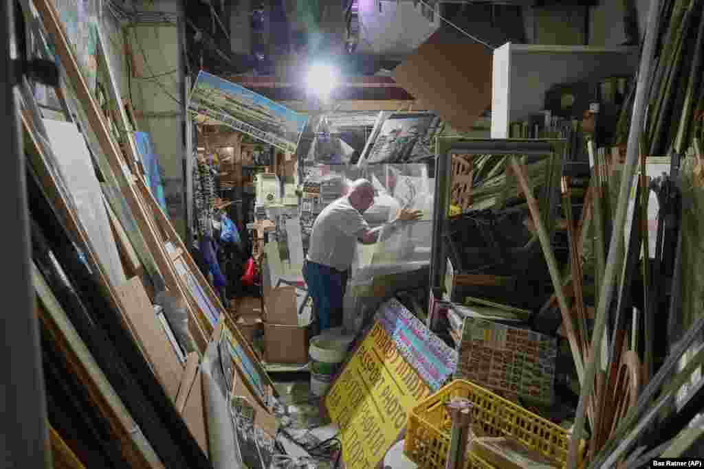 Një burrë duke inspektuar një dyqan të dëmtuar pasi një raketë e lëshuar nga Irani goditi Tel Avivin, më 16 qershor.