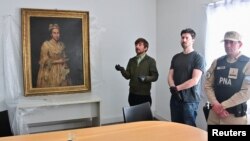 Кураторът Ариел Басано се обръща към медиите до портретa на контеса Колеони, откраднат преди 8 десетилетия от нацистите, 3 септември 2025 г.