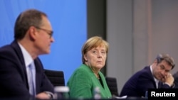 Njemačka kancelarka Angela Merkel, premijer bavarske države Markus Soeder i gradonačelnik Berlina Michael Mueller na konferenciji za novinare nakon što su s državnim premijerima razgovarali o produženju zaključavanja zbog COVID-19 , u Berlinu, 23. marta 2021.
