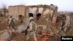 FILE: U.S. Marines walk through the rubble of a house destroyed in an airstrike in Helmand.