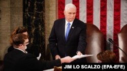 Bivši američki potpredsjednik Mike Pence predaje dokument tokom potvrđivanja izborne pobjede Joe Bidena, 6. januar 2021. 