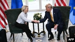 Președintele SUA, Donald Trump (dreapta), strânge mâna președintei Comisiei Europene, Ursula von der Leyen (stânga), după ce au convenit asupra unui acord comercial între cele UE și SUA.