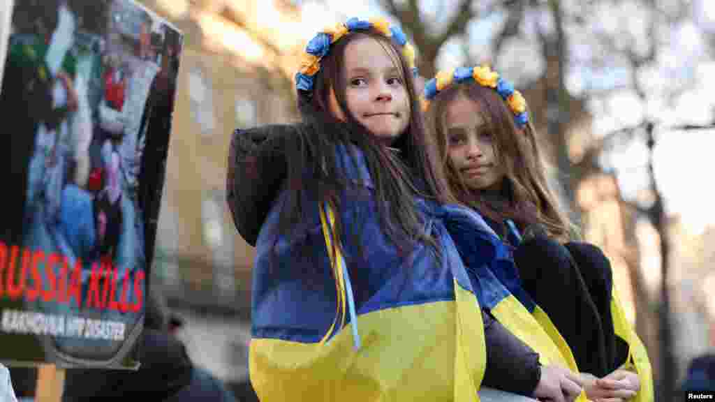 A hétéves Anasztaszija és a nyolcéves Alina ukrán zászlóba burkolózva vesz részt a Downing Street előtti tüntetésen Londonban 2025. március 2-án. A félbeszakadt washingtoni tárgyalás után Belgium, Horvátország, a Cseh Köztársaság, Észtország, Finnország, Írország, Horvátország, Lettország, Litvánia, Luxemburg, Hollandia, Portugália, Spanyolország, Svédország, Szlovénia és Svédország vezetői is Ukrajna támogatását fejezték ki, Orbán Viktor azonban az amerikai elnök mellett állt ki