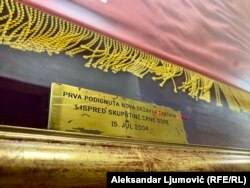 Natpis ispod državne zastave koja se prva zavijorila na zdanju Parlamenta Crne Gore 2004.godine, nakon usvajanja Zakona o nacionalnim simbolima