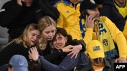 Suporterii suedezi reacționează la vestea atacului de la Burxelles care a dus la întreruperea meciului Belgia - Suedia.