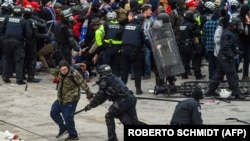 Donald Trump amerikai elnök támogatói összecsapnak a rendőrökkel és a biztonsági erőkkel, miközben megrohamozzák a Capitolium épületét Washingtonban, 2021. január 6-án