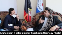 Hakeem Alakozai (R) talks with a an Afghan health ministry official in Kabul on May 30.