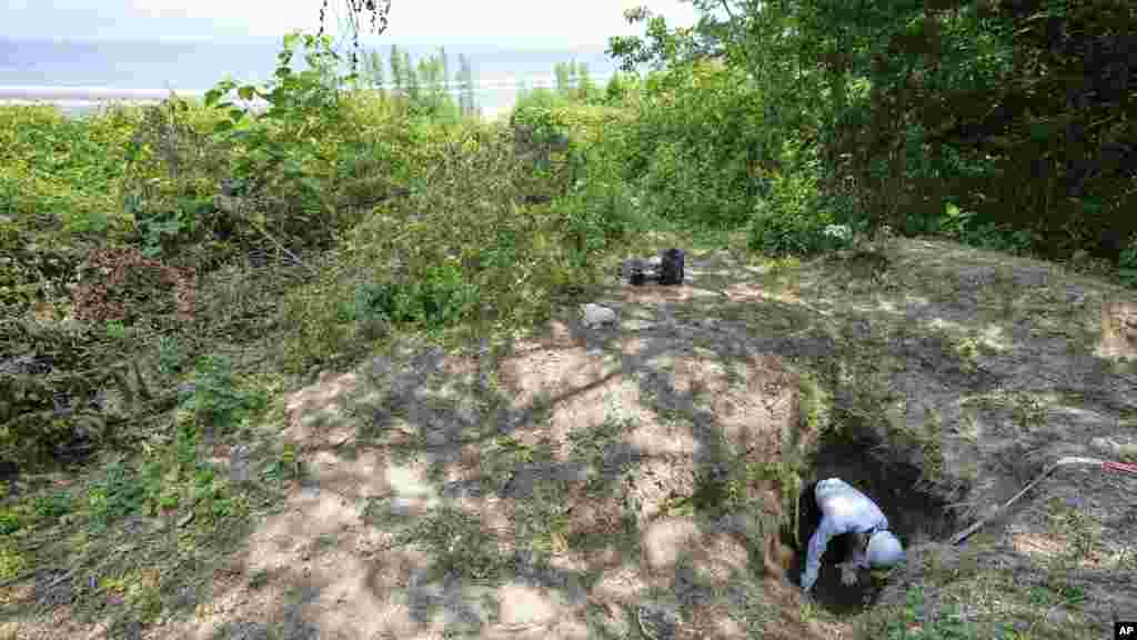 Rebun Kayo, a Hirosimai Egyetem kutatója, 2025. július 8-án a Hirosimában található Ninoshimában keresi az 1945-ös hirosimai atombomba áldozatainak maradványait