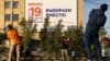 RUSSIA -- People do exercises in front of an election poster ahead of parliamentary elections in Yakutsk, September 7, 2021