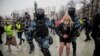 Служители на силите за сигурност задържат протестираща по време на демонстрациите в Русия