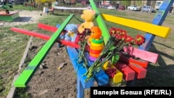 Цветы и игрушки на детской площадке в Кривом Роге, где в результате российского удара 4 апреля погибли, в частности, девять детей
