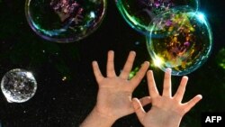 Аутизмге арналған қайырымдылық шарасында ойнап жүрген балалардың қолы. Көрнекі сурет