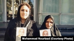 Gohar Eshghi (right) and her daughter hold photos of her son, Sattar Beheshti, who was killed in police custody.