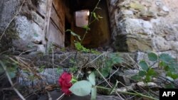 Cvijeće na ulazu u zapaljenu kuću u Gruborima, zaseoku pored Plavnog, oko 20 kilometara udaljenom od Knina, gdje je 25. kolovoza 1995. ubijeno petero starijih mještana srpske nacionalnosti