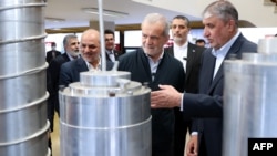 Președintele iranian Masoud Pezeshkian (centru) și șeful Organizației pentru Energie Atomică din Iran, Mohammad Eslami (dreapta), pe 9 aprilie la Teheran, la un eveniment de Ziua Tehnologiei Nucleare din Iran. 
