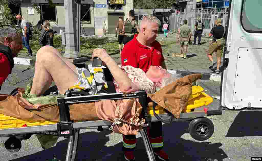 Спасатели эвакуируют пострадавшую женщину. Харьков, где живёт более миллиона человек, особенно уязвим перед атаками российских ракет и беспилотников