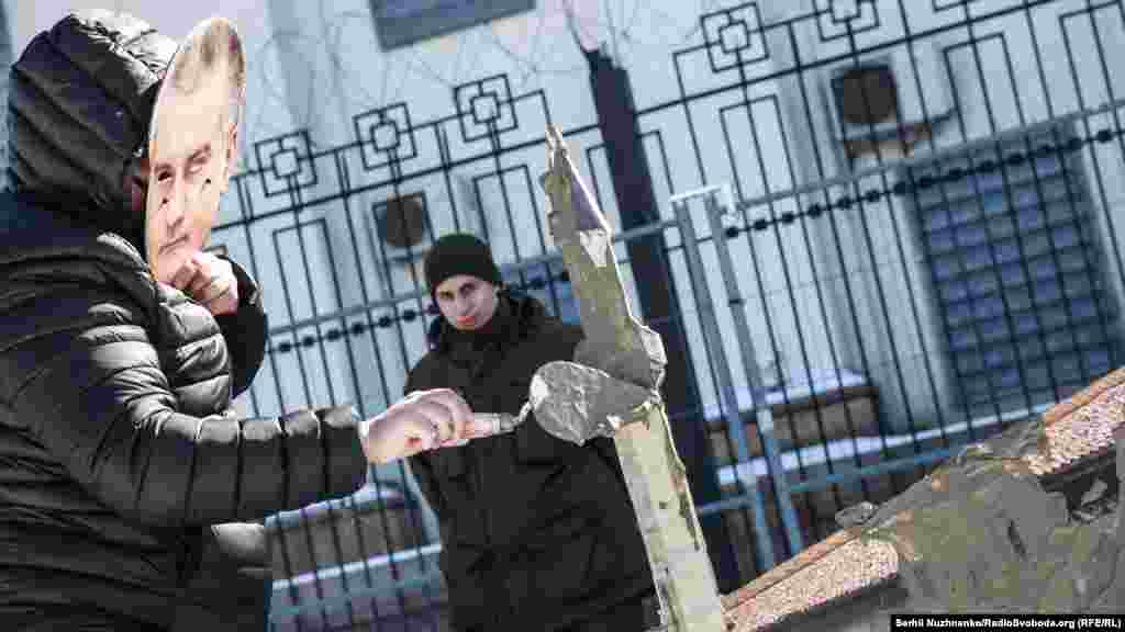 Активісти в масках президента Росії Володимира Путіна і глави підконтрольного Кремлю уряду Криму Сергія Аксенова (Аксьонова) «штукатурили» макет Ханського палацу