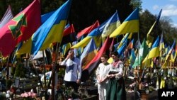 Роднини на загинати украински војници на молитва на нивните гробови, 20 април 2025