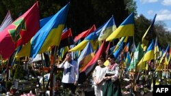 Porodica se moli ispred groba poginulog ukrajinskog vojnika na vojnom groblju na Uskrs u Lavovu.