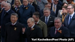 Hszi Csin-ping kínai elnök, Vlagyimir Putyin orosz elnök, Emomali Rahmon tádzsik elnök, mögöttük középen Robert Fico szlovák miniszterelnök, mellette Aleksandar Vučić szerb elnök a győzelem napi ünnepségen Moszkvában 2025. május 9-én