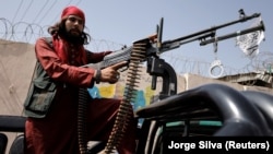 A member of the Taliban sits on a pickup truck mounted with a weapon in Kabul on October 3.