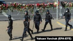 Policija prolazi pored mjesta na kojem je poginuo prosvjednik tijekom prosvjeda, Minsk, 11. kolovoza