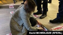 სოლიდარობის აქციის მონაწილეები მთავრობის კანცელარიის შენობის წინ აკრავენ სტიკერებს წარწერით "გაიფიცე!" თბილისი, 12 იანვარი, 2025.