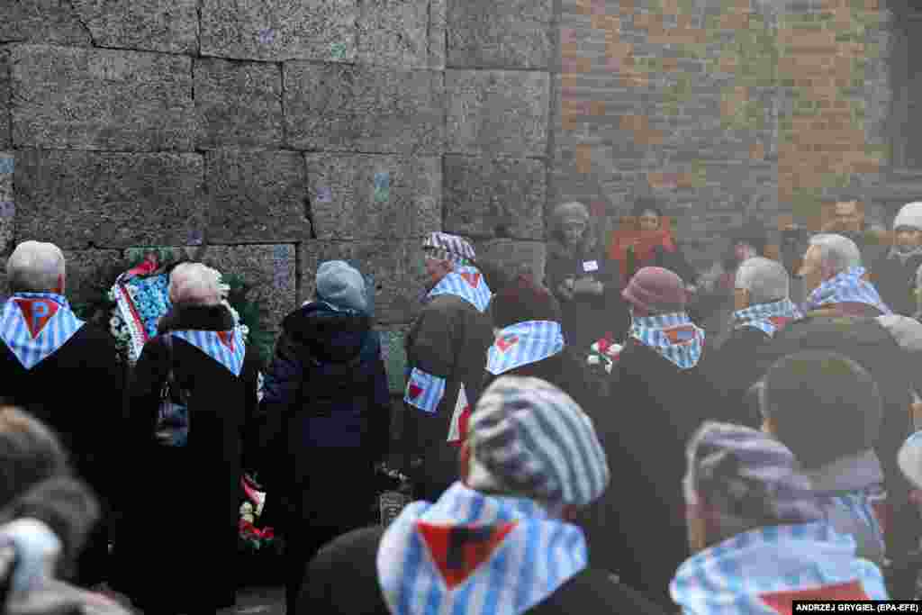 Бывшие узники лагеря возлагают венок к Стене смерти. Здесь расстреливали заключенных. Стена между двумя бараками, в которых было слышно все. 27 января 2020 года 