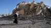 Palestinka prolazi pored uništene zgrade u gradu Gazi, fotografija iz 2021. godine