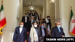 Iranian Foreign Minister Mohammad Javad Zarif (right) meets with senior Taliban leader Mullah Abdul Ghani Baradar (center) in Tehran in January. 