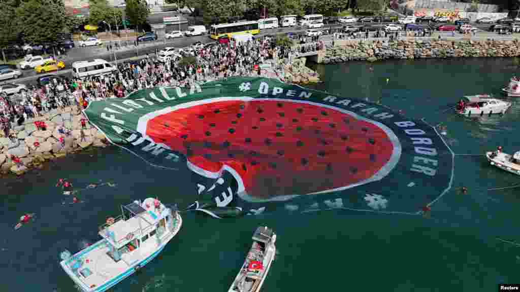 Pamjet nga droni tregojnë demonstrues propalestinezë në varka, teksa shpalosin një pankartë mbi ujë, gjatë një proteste në shenjë solidariteti me palestinezët në Gazë dhe kundër Izraelit, në Stamboll, Turqi, më 23 gusht 2025.