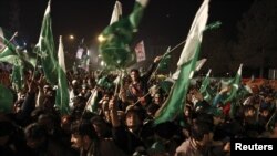 Supporters of Muhammad Tahirul Qadri, leader of Mihaj-ul-Quran, wave Pakistani flags during the protest in Islamabad on January 14.