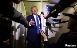 Дональд Трамп говорит с репортерами на борту президентского самолета на пути в Вашингтон