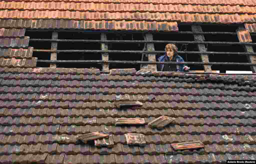 Žena na krovu oštećene kuće nakon zemljotresa magnitude 5,2, u selu Brest Pokupski, Hrvatska, 28. decembra 2020. REUTERS / Antonio Bronic